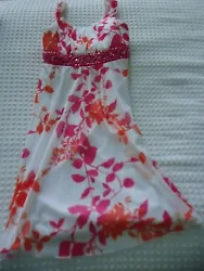 Fine condition girls size 8 sleeveless fancy dress in white with pink and orange floral pattern. Attached white slip...