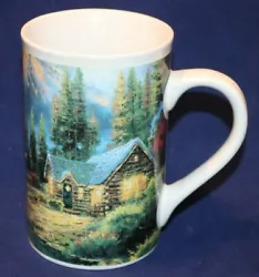 Thomas Kinkade Tall 16 oz Coffee/Tea Cup. Cup shows a Cabin on the Lake in an Evergreen Forest with mountains in the...