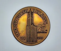 The front is embossed with a highly detailed relief of the Woolworth Building from top to bottom. It reads 