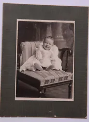 Depicts: Child sitting on corner chair. Backprint: Sands photographic over 104 Main St Lockport, NY. Size: 4.5x5.75