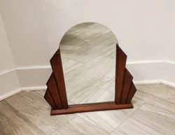 The wood panels may be cherry wood. The mirror backing and base pase appear to be tiger oak. A wood nick is visible on...