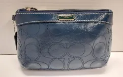 This gorgeous blue stitched wristlet is in great used condition with mild preowned wear on the exterior and interior...