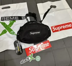 This black nylon Supreme waist bag from the SS18 collection is a must-have for any fashion-forward man. It features an...