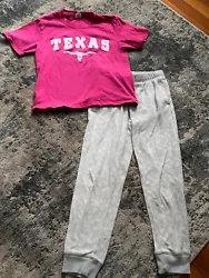Pajama set with Size S pink Texas shirt and Size 8 Old Navy fleece pajama bottoms.  Gray background with large white...