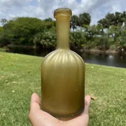 It has a fluted neck and thick lip and pontil mark on base. A beautiful and unique bottle with light amber color. We...