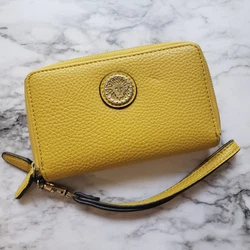 Yellow Anne Klein wristlet wallet in decent condition. Wallet is a bit worn on the corners and has a small dent on the...