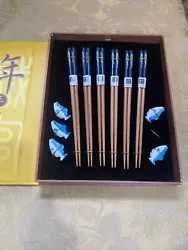 Yunhong Chopsticks with rests. In decorative case. Case was damaged and repaired with tap. The 6 pair chopsticks appear...