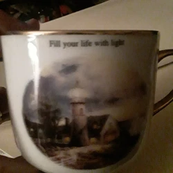 Thomas Kinkade Artist Coffee or Tea Mug. from the Lights in a Storm collectors mug. White with gold handle. On the top...