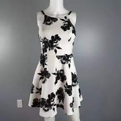 Speechless dress in white with black/gray floral print has back zip closure with ribbon tie. Dress has pockets. Size 1...