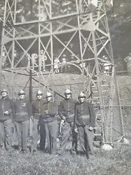 Groupe de 10 pompiers en tenue de travail et 2 officiers. Je pense des années 1920.