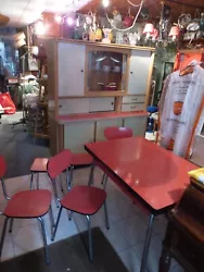 Exceptionnel des années 50 en formica rouge. 1 buffet + table + 3 chaises + 2 tabourets, le tout assorti. 3 chaises (1...