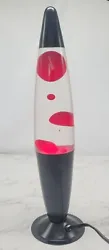 This lava lampnis is in excellent condition. Black base and top with red wax. It looks pink in the dark just because of...