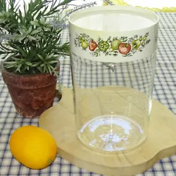 The tall glass jar features a vegetable decorated plastic “locking” lid. The jar is marked “Pyrex/Made in USA”....