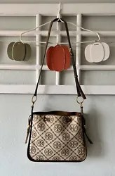 This Tory Burch Mini T Monogram Crossbody Bag is a stylish accessory for any woman. The bag features a brown canvas and...