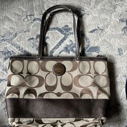 This Coach Signature Stripe tote bag is a stylish and practical accessory for any woman. Made of canvas and leather, it...
