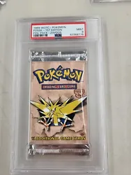 This PSA 9 Pokemon Fossil Booster Pack features a 1st edition foil Zapdos card from 1999 by Wizards of the Coast. The...