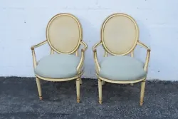 This charming pair of chairs is made of wood, caning, and fabric. These two chairs would add a delightfully French...