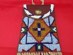 Reproduction Sioux Style Beaded Strike A Light Bag. Brain tan hide fringe with tin cone on the fringe. 6 1/2