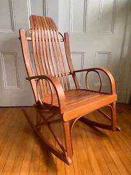 The wood, is cherry wood, I believe with smooth grain. Seat curves down. Very comfortable. Rounded arms. slat back....