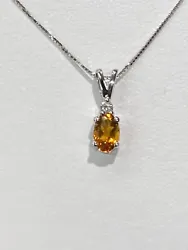 The item is a 14k white gold citrine and diamond pendant. The diamond is round and weighs 0.03 carats. The diamond has...