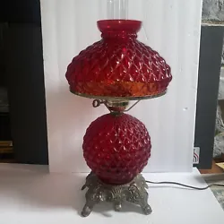 With a unique red globe and quilted pattern, it exudes a classic charm perfect for creating a cozy atmosphere. The lamp...