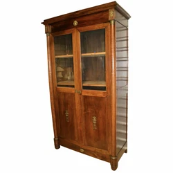 The doors are flanked by two mahogany columns that have Corinthian style capitals in brass as well as ornate brass...