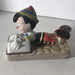 Disney Pinocchio Reading Book Small Bisque Figurine. Height of 2” with a length of 2 3/4” and a width of 1 1/2”....