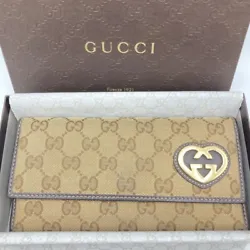 This authentically used Gucci purse is a long wallet that features a brown canvas and leather design with the iconic GG...