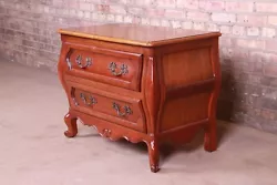 A beautiful French Provincial Louis XV style bombay chest or commode. By Baker Furniture. Cherry wood, with original...
