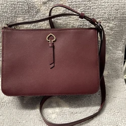 kate spade crossbody burgundy. L 9 1/2H 6 1/2D 3 1/2Strap drop 21”All zippers work no ink marks on lining.