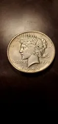 This is a 1921 Peace Silver Dollar $1 coin from the United States. It is composed of silver, has a denomination of $1,...