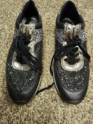 Elevate your sneaker game with these Michael Kors Allie Trainer sneakers. The black glitter and silver accents add a...