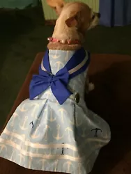 This is a dress for a small dog such as a Chuhuahua or small Terrier. The dress is a sailor dress of light blue with...
