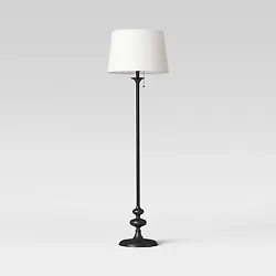 •Black metal stick floor lamp with a turned base and fabric drum shade •White linen shade diffuses light with a...