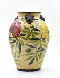Vase en céramique à décor floral et têtes de lion en relief. Céramique italienne. État : Quelques éclats dans...