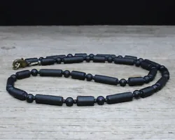 Thin, black necklace features matte black onyx rounds, and matte black glass tubes with black seed bead spacers. The...