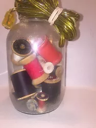 Hazel Atlas mason jar lamp filled with vintage thread spools.