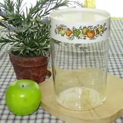 The tall glass jar features a vegetable decorated plastic “locking” lid. The jar is marked “Pyrex/Made in USA”....