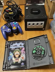 Luigis Mansion and GameCube console with cords and a controller.  The game has scratches but both the game and the...