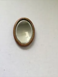 Ancien petit miroir oval en bois pour poupée ou décoration. Petite fente sur le haut du cadre.
