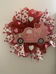 This is a pretty deco mesh valentines wreath. I used red deco mesh on a wire frame. I added a cute truck and pink...
