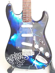 Guitare miniature réalisée en lhonneur du groupe de Rock Dire Straits qui connut son heure de gloire dans les années...