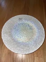 This is a Turkish, handmade cake stand by Akcam. It is white and a textured glass. There is an iridescence to it.
