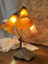 Inspired by Tiffanys famous Pond Lily design from the early 1900s, this table lamp is created with three mouth blown...