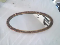 THIS IS A OLD SMALL OVAL SHAPED MIRROR.MEASURES OVER 17 INCHES TALL 9 INCHES WIDE.FRAME LOOKS GOLD PLASTIC WITH A 3D...