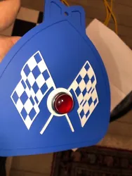 MUDFLAP IN BLUE WITH BLUE & WHITE CHECKERED CROSS FLAGS AND RED JEWEL. YOU GET ONE MUDFLAP IN BLUE. WITH CHECKERED...