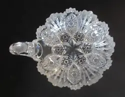 It is clear and has a cut glass design. This dish is in excellent condition.