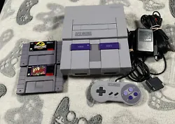 This Super Nintendo SNES console bundle comes with two games, Jurassic Park and Taz, and has been tested and cleaned...