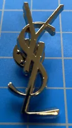 Elevate your style with this vintage Yves Saint Laurent lapel pin brooch. Crafted from mixed metals in a sleek silver...