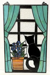 The hand-cut stained glass pieces and round cabochons fit together into a colorful, artistic display. -Features a black...